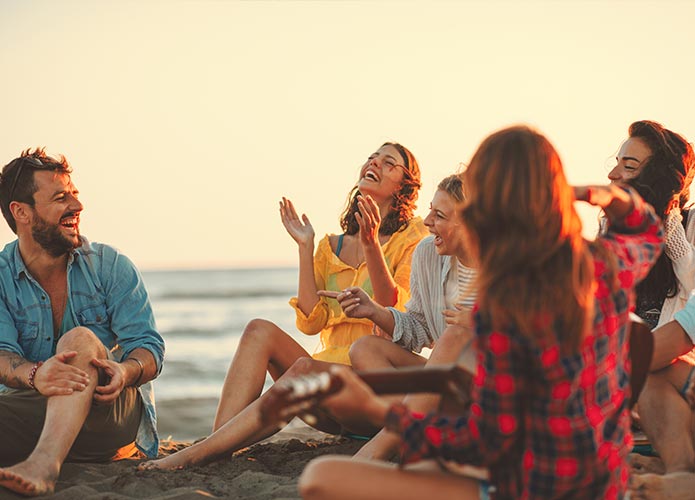 Group of friends laughing at the beach