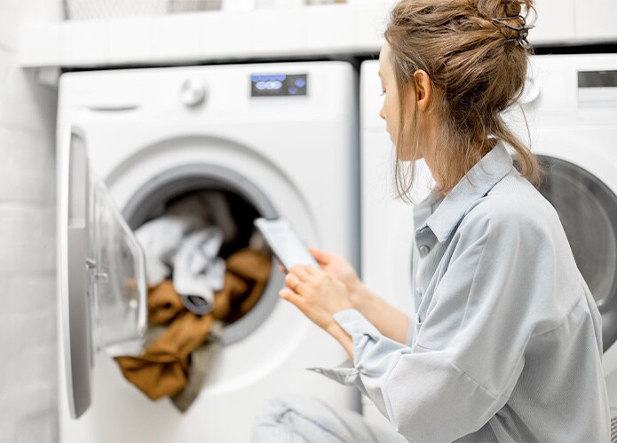 Woman using smart washing machine
