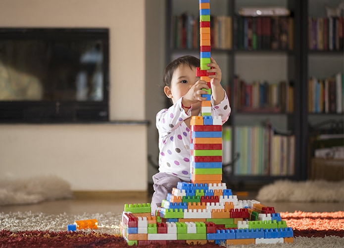 Toddler building Lego tower