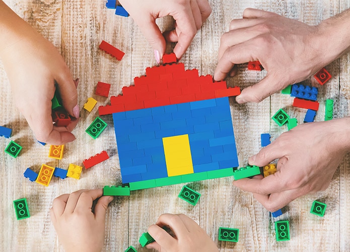 Hands building Lego house